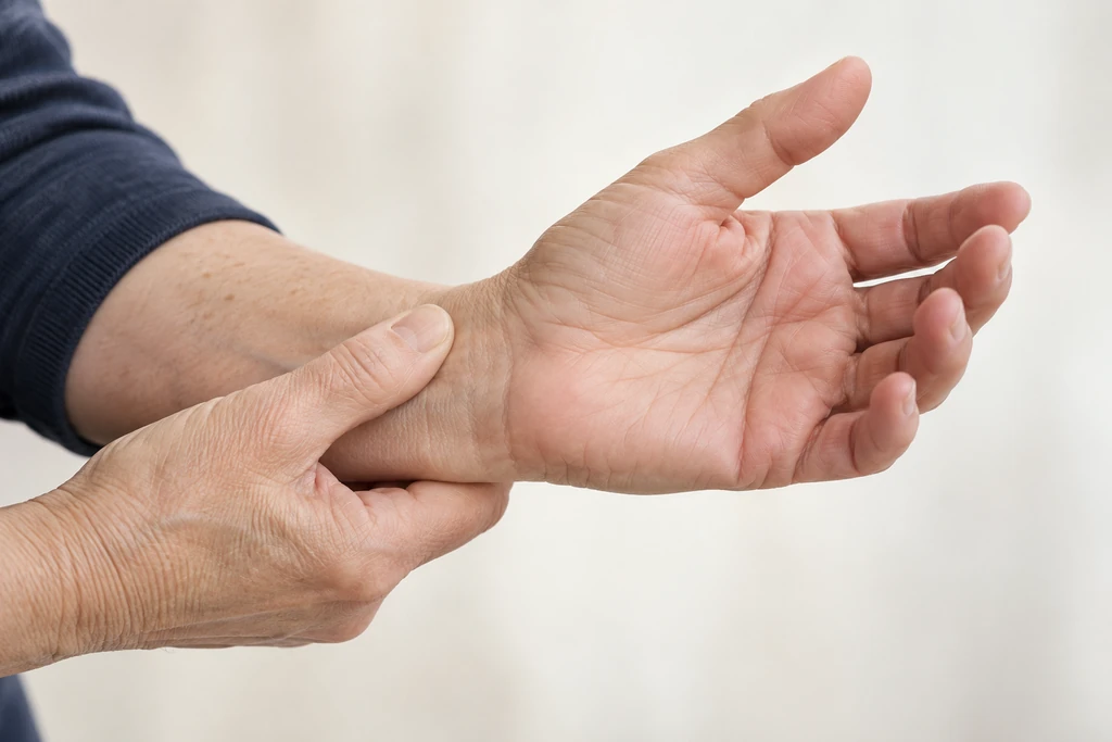 Close-up of a hand gently supporting the opposite wrist.