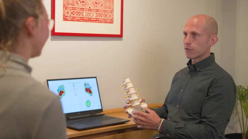 A Severn practitioner explaining a spinal model during a consultation.