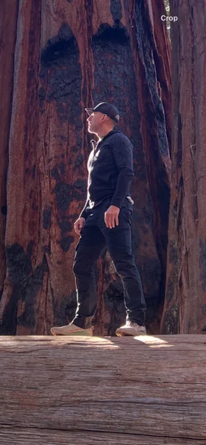 Toby standing beside a large tree