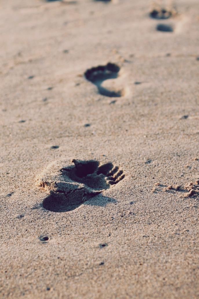 A trail of footprints across sand.