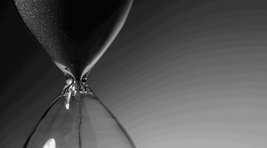 Close-up of sand passing through an hourglass.