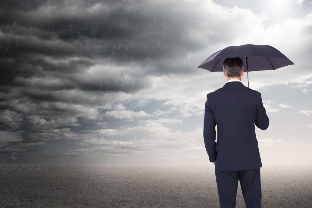 Person holding an umbrella beneath dark storm clouds.